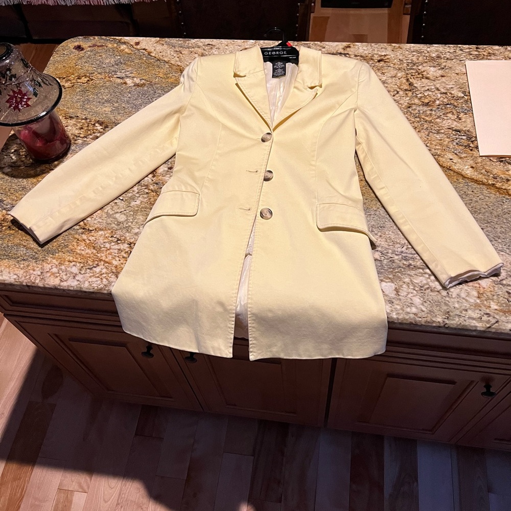 Pale yellow spring, lined mid length coat.